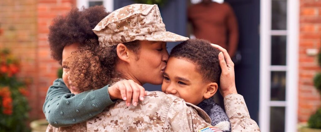 American female soldier returning home to family and hugging children
